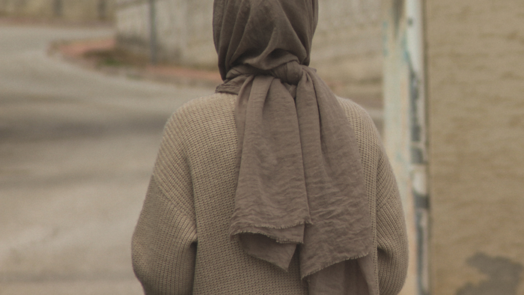 Stojąca tyłem dziewczyna w hidżabie.